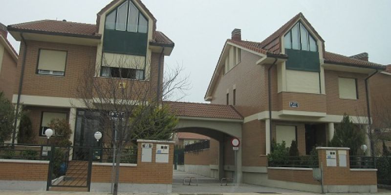Vista de calle de dos chalets unidos por un arco de ladrillo en Camino de la Flecha