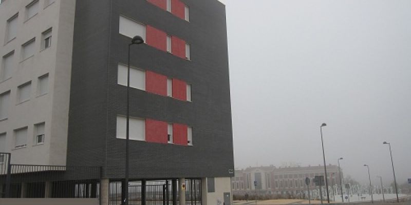 Vista desde la calle de bloque de viviendas oscuro, enfrente de la Vega